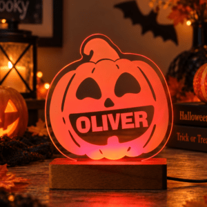 Personalised pumpkin LED light with a custom name on a wooden base, glowing as a Halloween gift for children.
